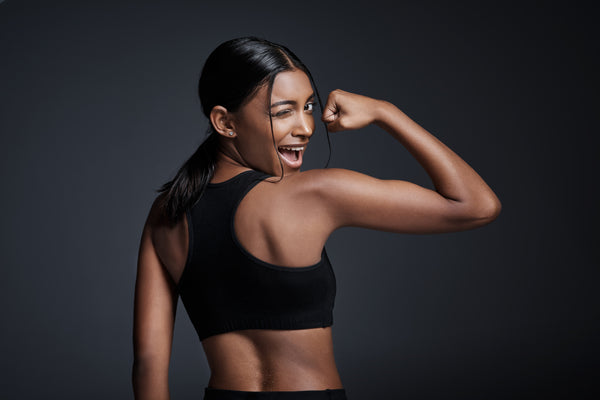 Young woman flexing her bicep and winking